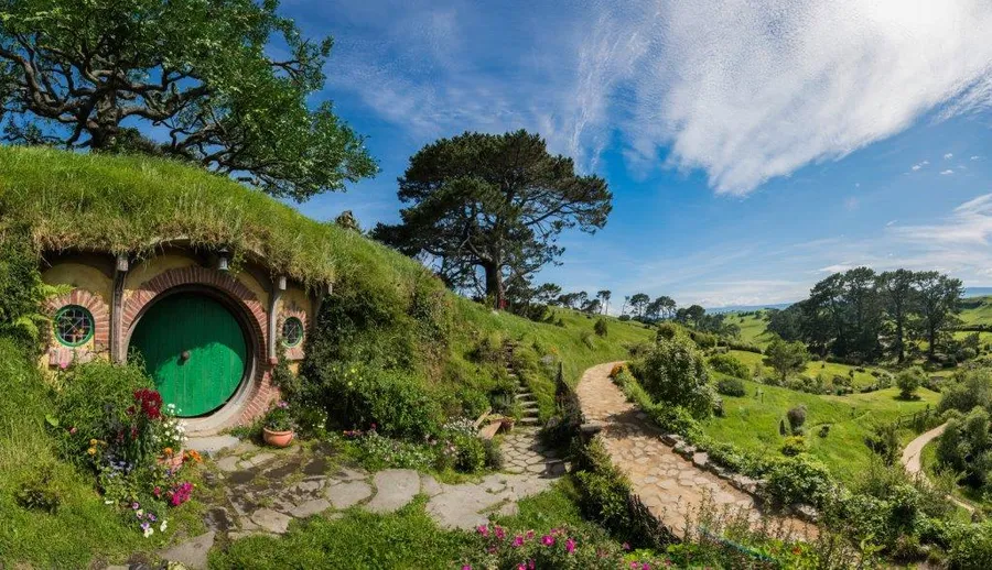 Hobbit hole with a green round door at the Hobbiton Movie Set
